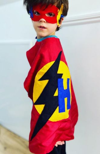 red superhero cape and eye mask worn by child