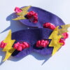 purple felt superhero eye mask with gold and yellow lightning bolts and pink elasticated strap